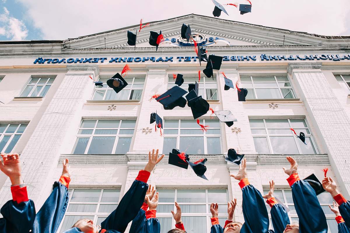 traffic light group of fresh graduates students throwing their academic hat in the air human